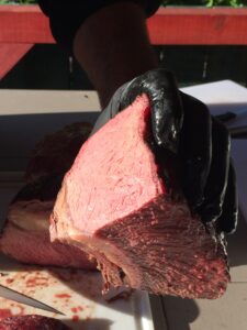 Männerhand mit rosa gebratenem Fleichstück in der Hand