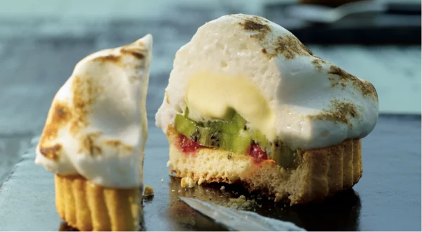 Eis vom Grill aufgeschnitten, unten Teig, darüber Früchte und Eis mit einer Haube aus Baizer