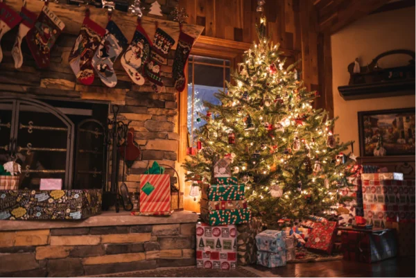 Uriges Weihnachtszimmer mit üppig geschmückten Weihnachtsbaum und darunter liegenden Geschenken